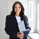 Lavallette Realtor® in a dark colored suit and light colored shirt holding a folder